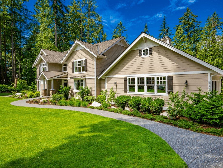 A craftsman-style home with a curved lawn and gravel drive